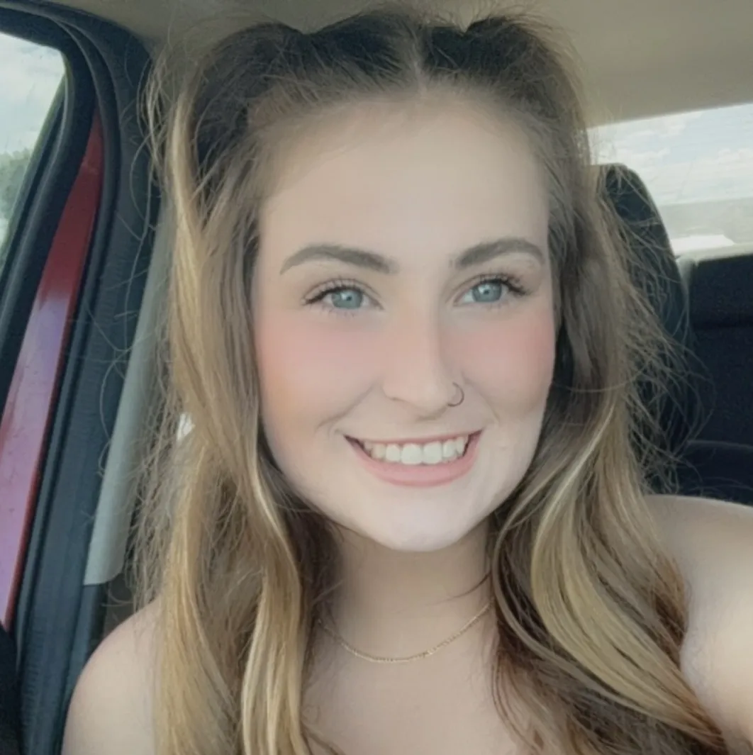 Cassidy smiling in her car